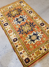 Load image into Gallery viewer, Angled view of th Turkish Wool Rug with geometric patterns, 4 medallions aternating in Gold and Black